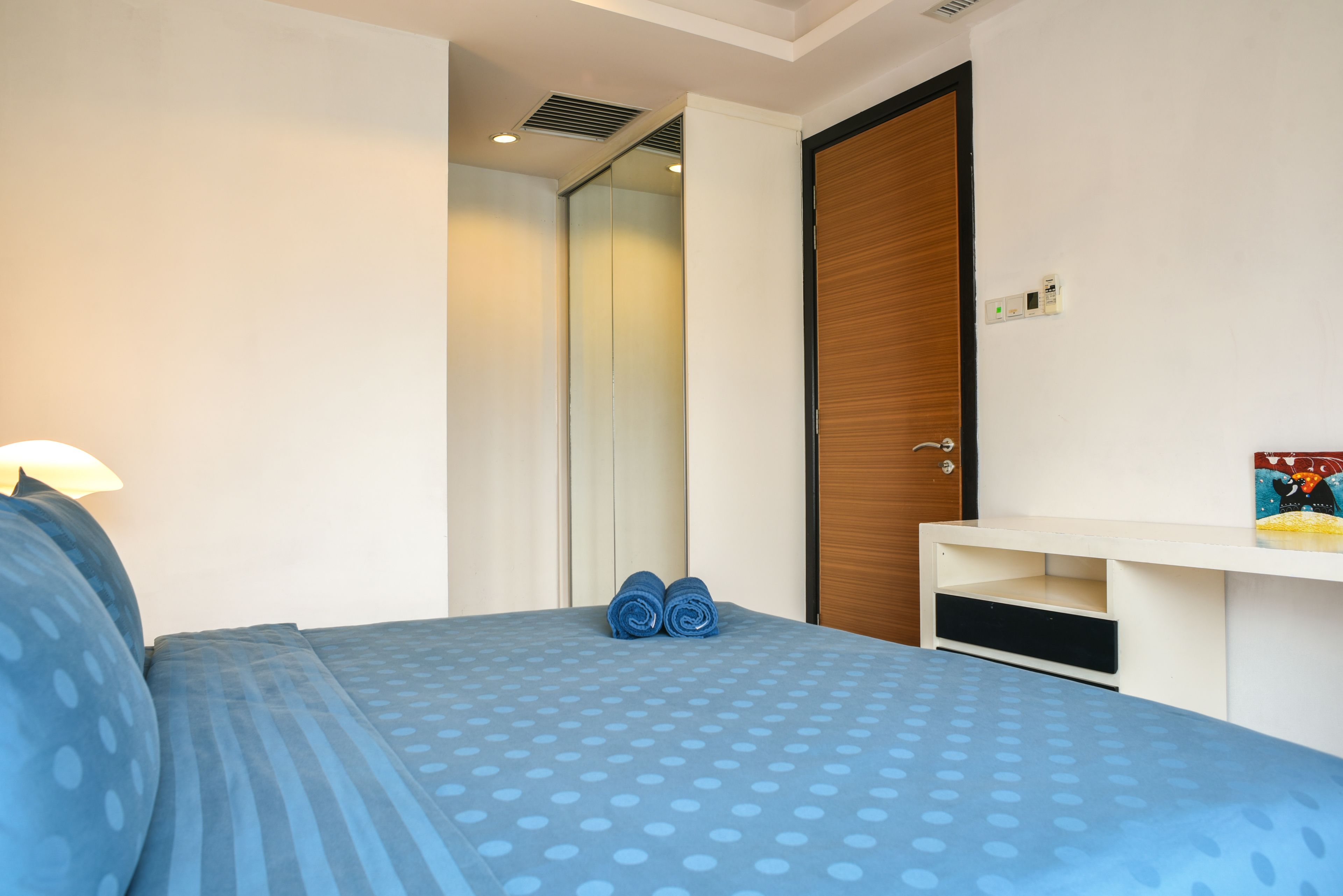 Une chambre d’hôtel avec un lit, un bureau et une armoire.
