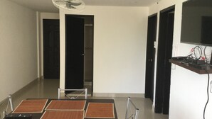 Un comedor con una mesa dispuesta para cuatro personas, un ventilador de techo y un televisor montado en la pared.