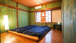 A room with a bed, a window, and a small table. - Hostel KIKO (Sendai)