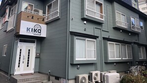 A two-story building with a sign for "KIKO GLOBAL MEETS LOCAL" on the ground floor. There are multiple air conditioning units on the ground level. - Hostel KIKO (Sendai)