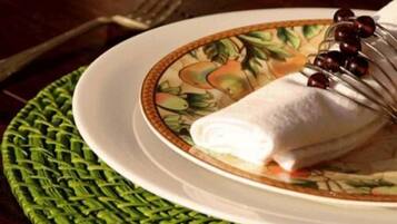 A plate with a rolled item and a decorative plate with a fruit pattern.