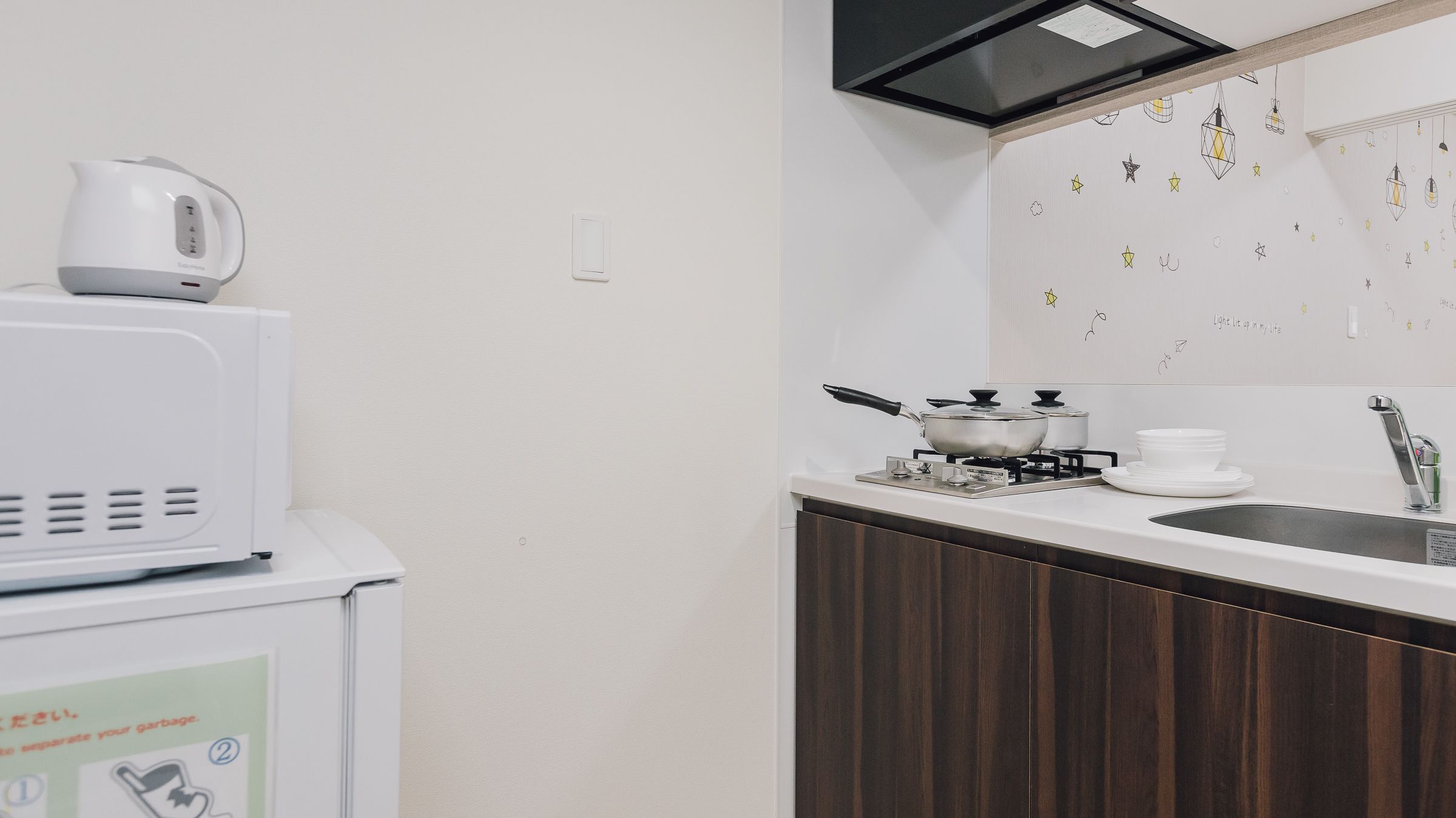 A compact kitchen with a microwave, stove, and sink.