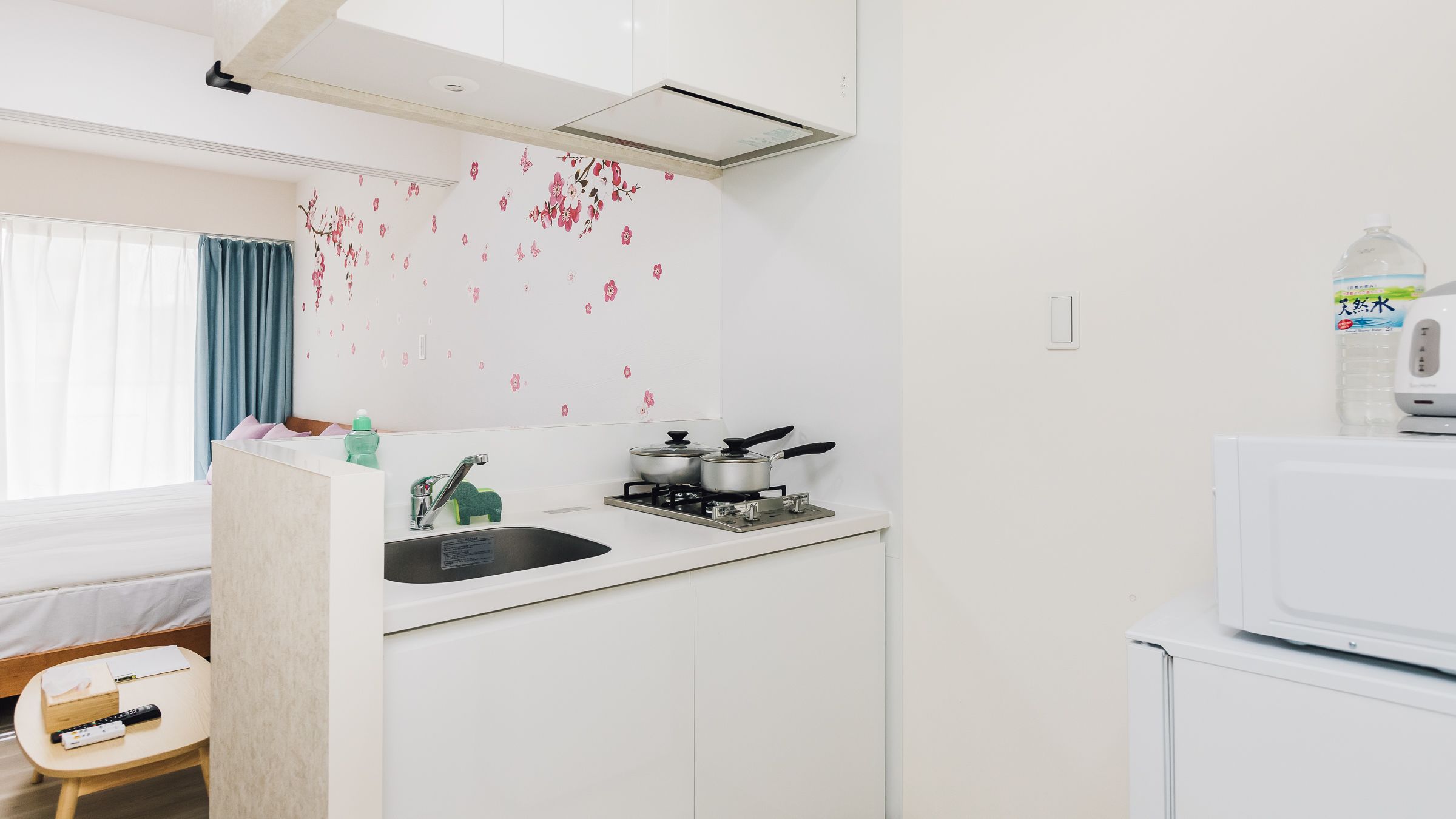 A compact kitchenette with a gas stove, a microwave, and a sink.