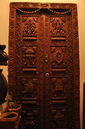 Una puerta de madera con intrincados grabados, incluyendo motivos florales y figuras de animales.