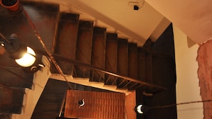 Un escalier avec des marches en bois et des rampes en métal, menant à un niveau inférieur.