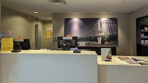 A hotel reception area with a large bridge mural, a reception desk, and a snack bar. - Staybridge Suites Scottsdale - Talking Stick by IHG (Scottsdale)