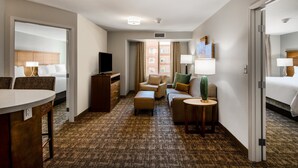 A hotel room with a bed, a desk, a chair, a sofa, a small table, and a TV. - Staybridge Suites Scottsdale - Talking Stick by IHG (Scottsdale)