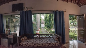 Una habitación con una cama, un escritorio y vista a un jardín.
