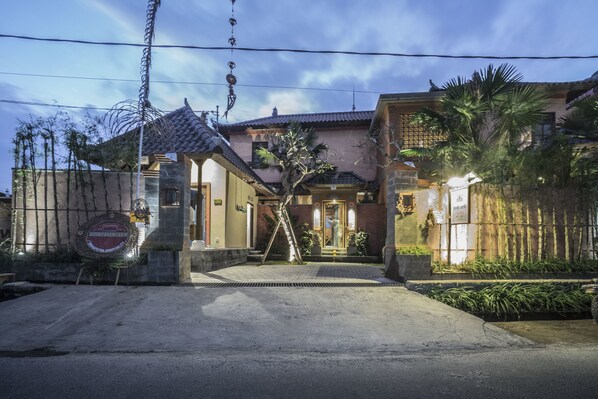 A traditional-style building with a tiled roof, a gated entrance, and a well-maintained garden.
