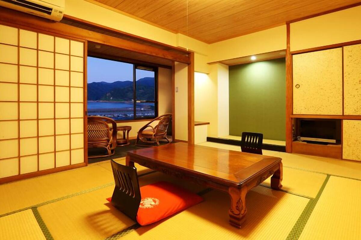 Ein traditioneller japanischer Raum mit Tatami-Böden, einem niedrigen Tisch und Schiebetüren.