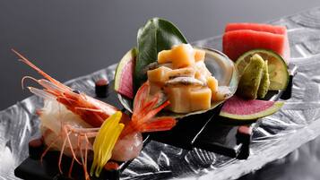 Variedad de mariscos y frutas dispuestas sobre una bandeja negra.