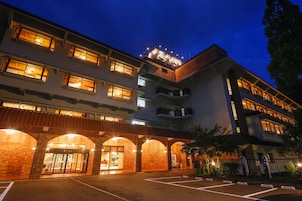 Un hotel de varios pisos con ventanas iluminadas y fachada de ladrillo.
