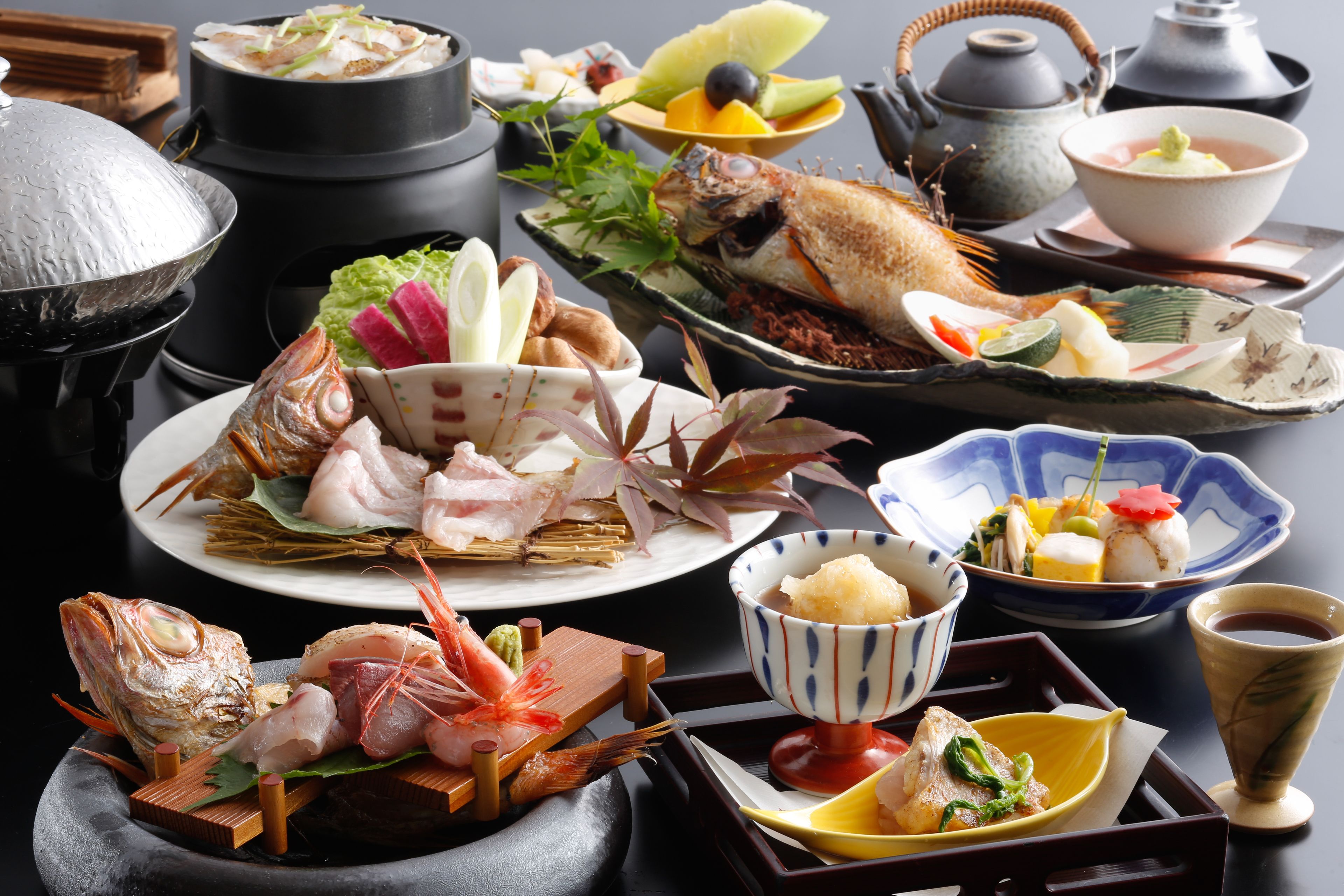 A variety of seafood dishes and traditional Japanese utensils on a table.