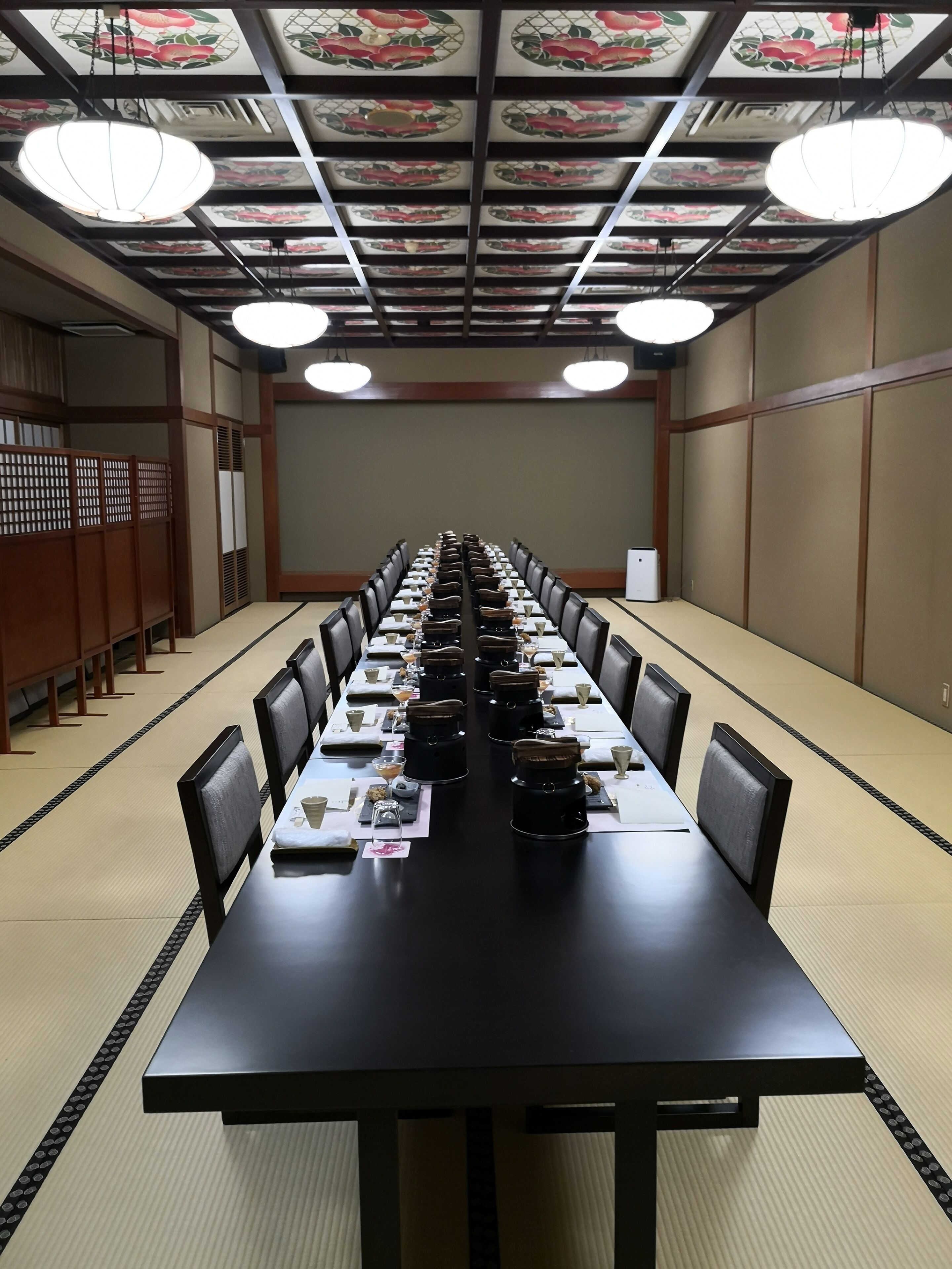 A conference room with a long table, chairs, and a decorative ceiling.