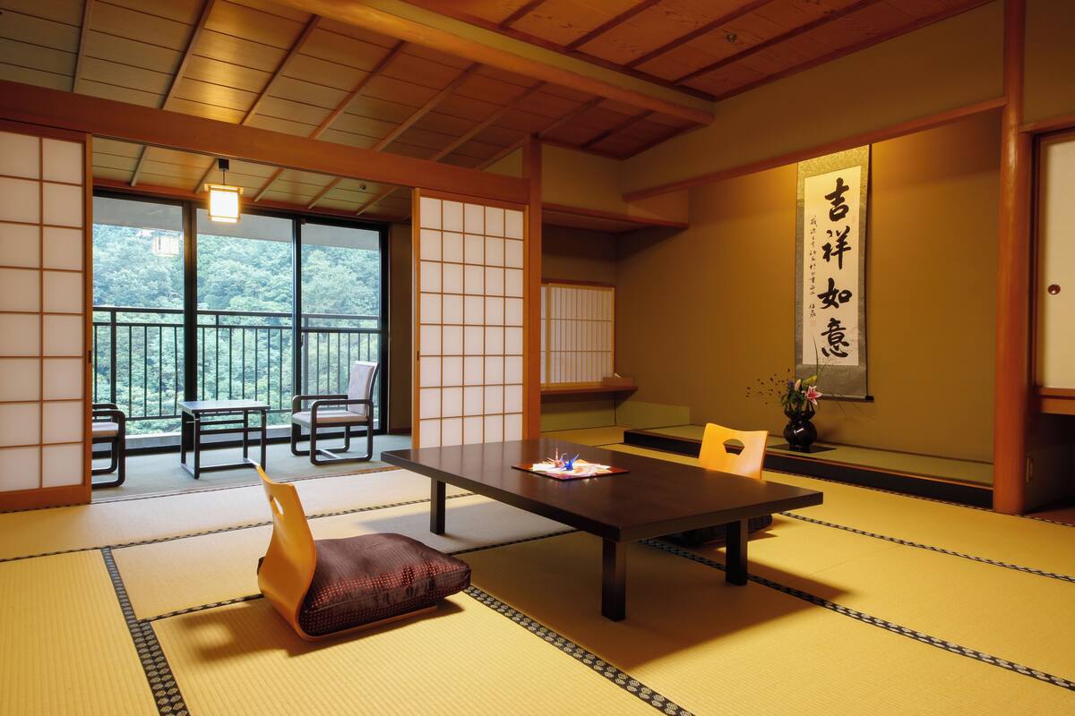 A traditional Japanese room with tatami flooring, a low table, and sliding doors.