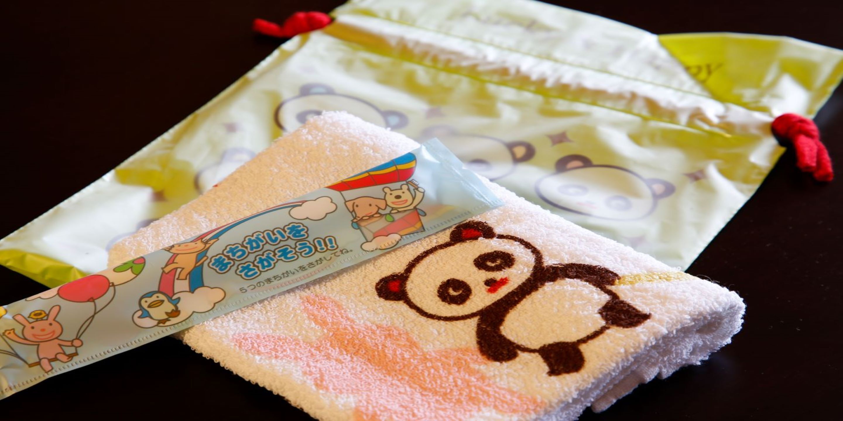 A package with a cartoon panda design and a towel with a similar panda design.