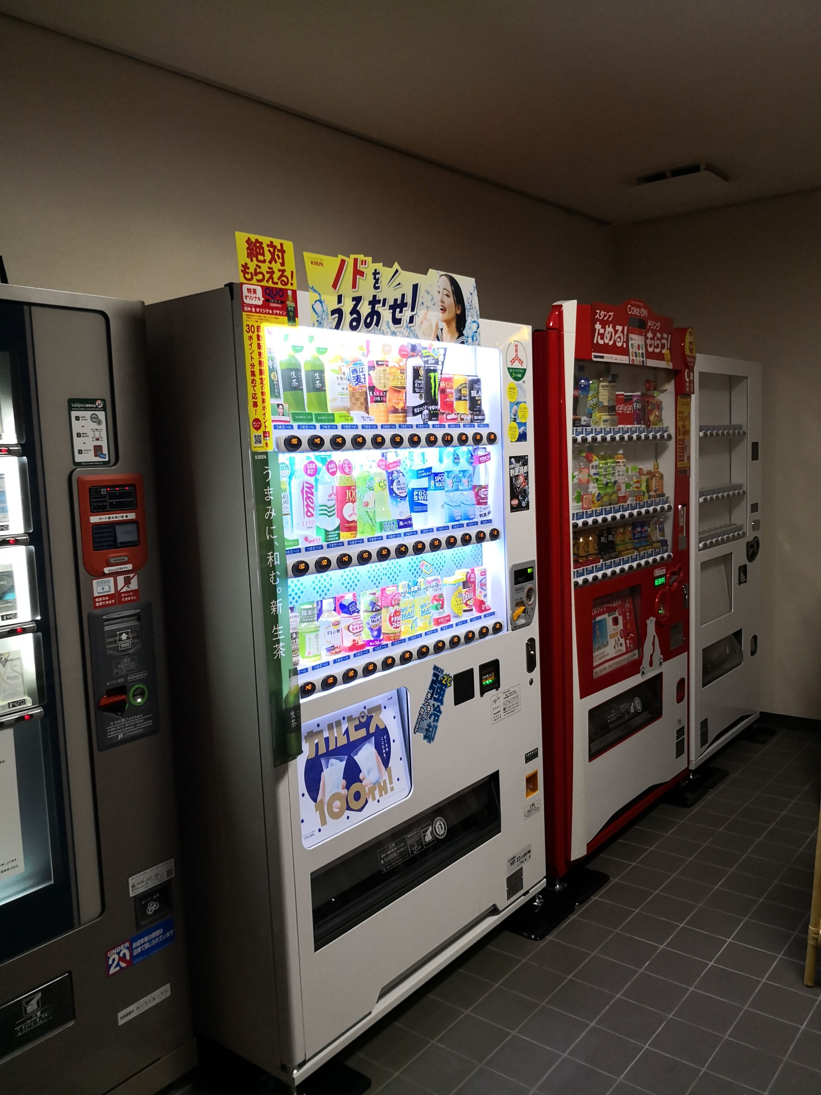 Una fila di distributori automatici con diverse bevande e snack.