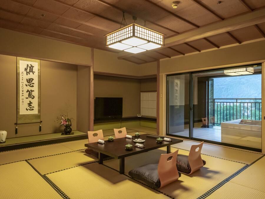Um quarto japonês tradicional com tatames, uma mesa baixa e biombos shoji.