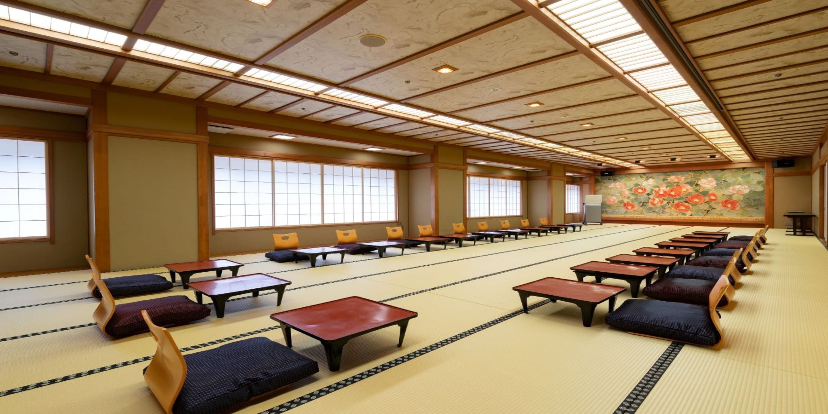 Una habitación tradicional japonesa con esteras de tatami, mesas bajas y cojines.