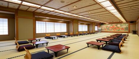 Una habitación tradicional japonesa con esteras de tatami, mesas bajas y cojines.