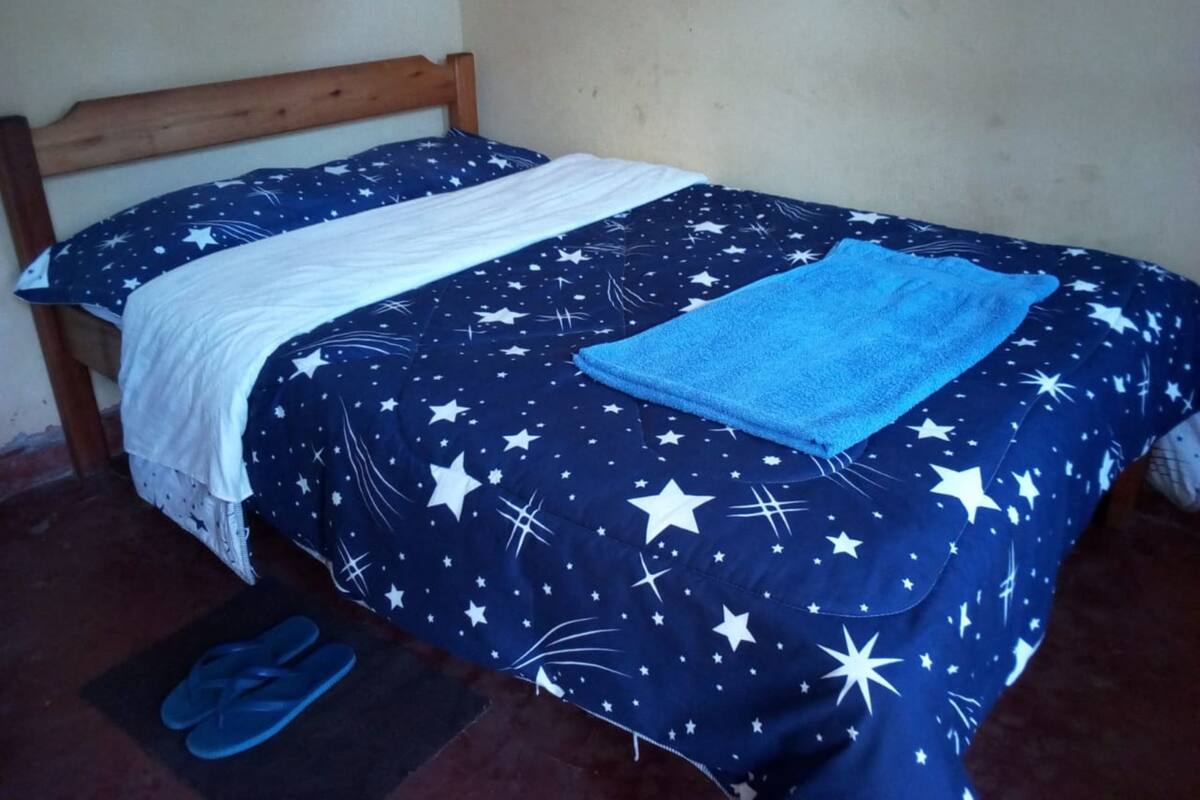 Ein Bett mit einem Sternenmuster auf der Bettdecke und einem blauen Handtuch.