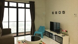A modern living room with a large window, a flat-screen TV, a sofa, a coffee table, and a ceiling fan. - YOYO Homestay (Johor Bahru)