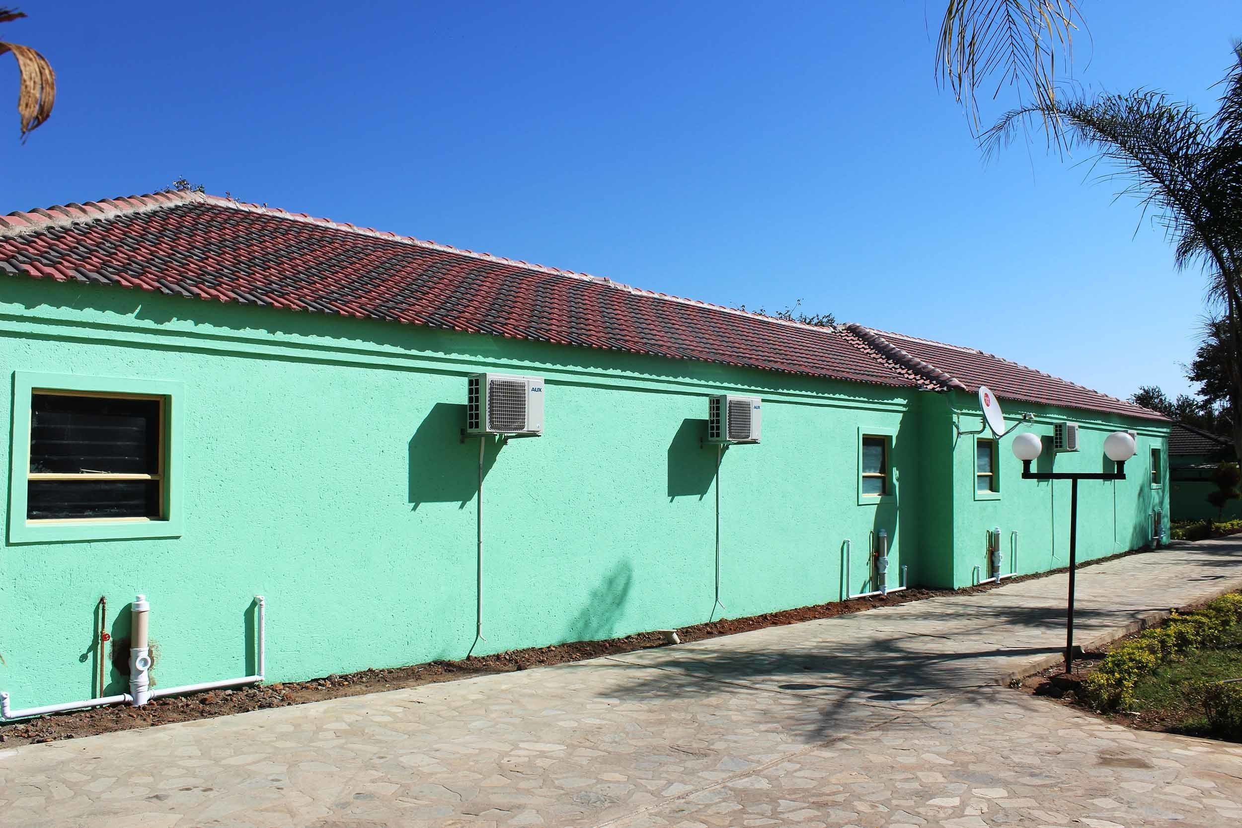 A building with a tiled roof and air conditioning units.