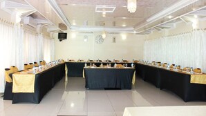 A conference room with long tables, chairs, and a chandelier. - Mashamba Country House (Giyani)