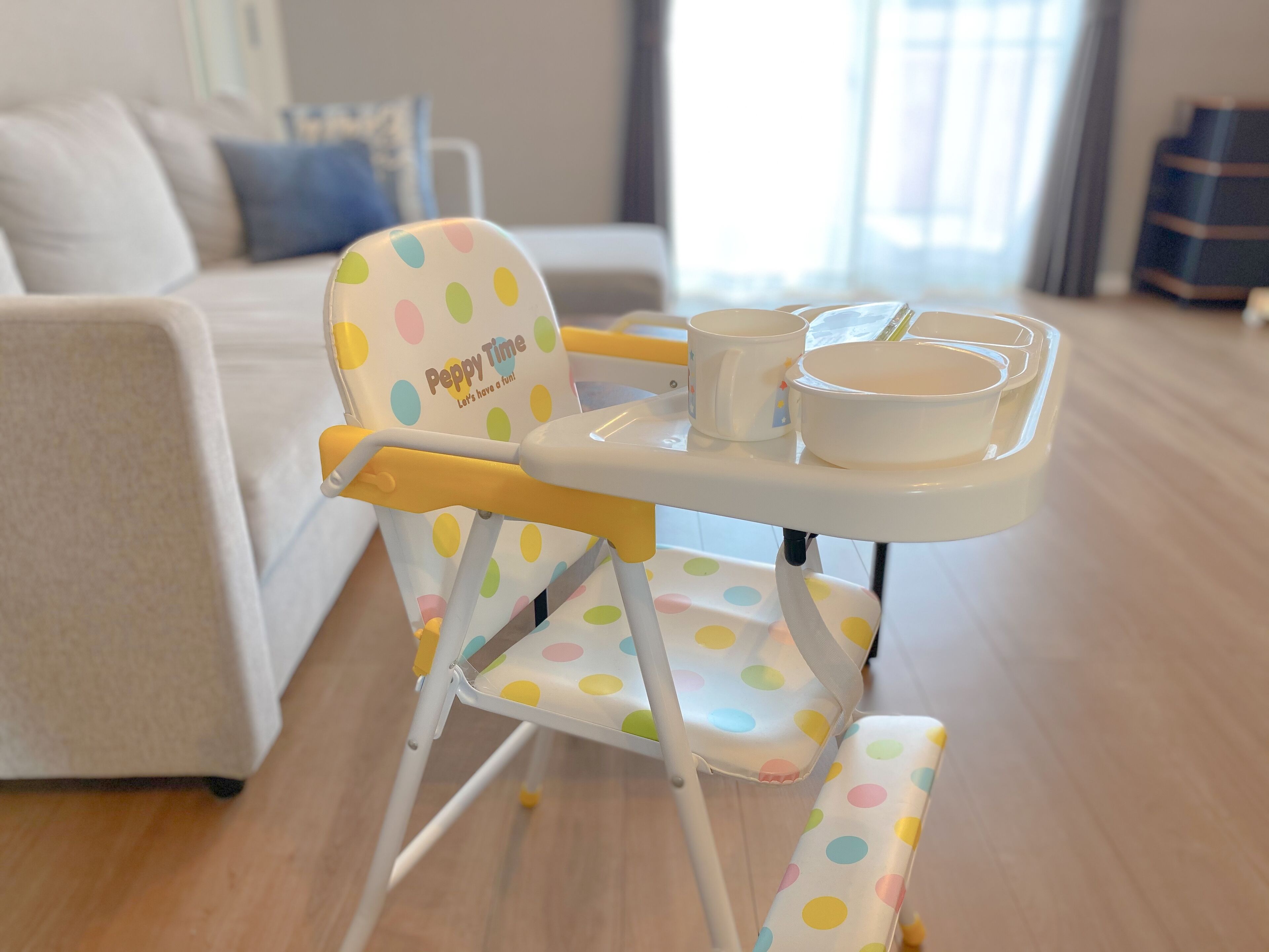 Een klein eetgedeelte met een gestipte stoel, een witte tafel en een kom.