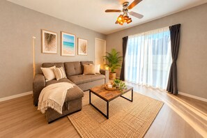 A living room with a sofa, coffee table, and a ceiling fan. - Grandioso Okinawa Pool Villa Onna 4 (Onna)