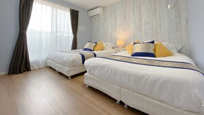 A hotel room with two beds, a bedside table with a lamp, and a large window with curtains. - Grandioso Okinawa Pool Villa Onna 4 (Onna)