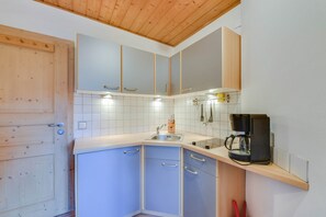 Eine Küche mit Holdekor, einer Spüle und einer Kaffeemaschine.