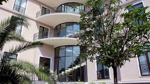 A multi-story building with balconies, large windows, and a staircase leading to the upper floors.
