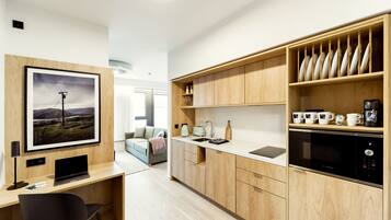 Una cocina moderna con armarios de madera, lavavajillas integrado y una encimera con diversos electrodomésticos.