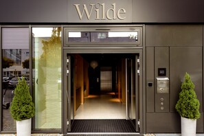 A hotel entrance with a name sign 'Wilde' and an elevator. - Wilde Aparthotels, Berlin, Checkpoint Charlie (Berlin)