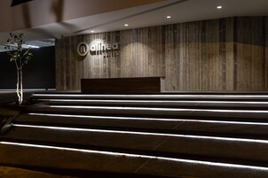 Un área de recepción con una pared de madera y un letrero que dice "Alinea Suites".