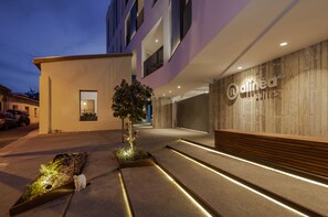 A modern hotel entrance with a well-lit pathway, a small garden area, and a visible sign for 'Alinea Suites'. - Alinea Suites Limassol Center (Limassol)