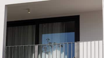 Un balcon avec des garde-corps en métal et une table avec des chaises.