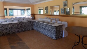 Una sala conferenze con un tavolo a motivi zebrati, sedie bianche e ampie finestre.