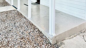 A single-story building with a covered porch, a door marked "4580", and a gravel driveway. - The Cozy Murray Bungalow fast WIFI free parking!  (Murray)