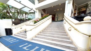 A hotel entrance with a blue carpet with 'LIKAI' written on it, marble stairs, and a stone balustrade. - Ilikai Apt 302 -Newly Renovated October 2025- Studio with  Ocean & Harbor Views Modern Updates (Waikiki)