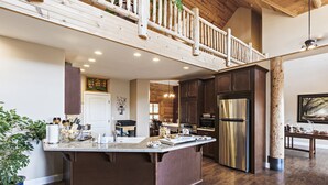 A spacious kitchen with a large island, dark wooden cabinets, stainless steel appliances, and a wooden balcony. - Mountain Cabin/Pine Flat Lake/Kings Canyon/Sequoia National Park/Yosemite (Piedra)