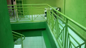 A green stairwell with metal railings and a tiled floor. - Elpaso Lodge (Karatina)