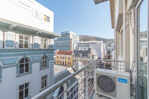 Un edificio alto con una vista despejada del paisaje urbano, que incluye varios estilos arquitectónicos y una colina distante.