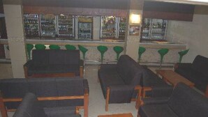 A bar area with multiple seating arrangements including sofas and chairs.