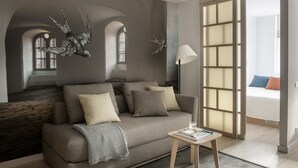 Ein modernes Wohnzimmer mit einem grauen Sofa, einem kleinen Holztisch und Wanddekoration.