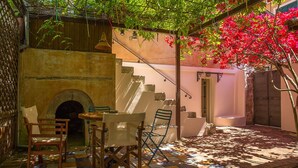 A courtyard with a tiled floor, a stone fireplace, and outdoor seating. - Lefkada's traditional house / cozy yard (Lefkada)