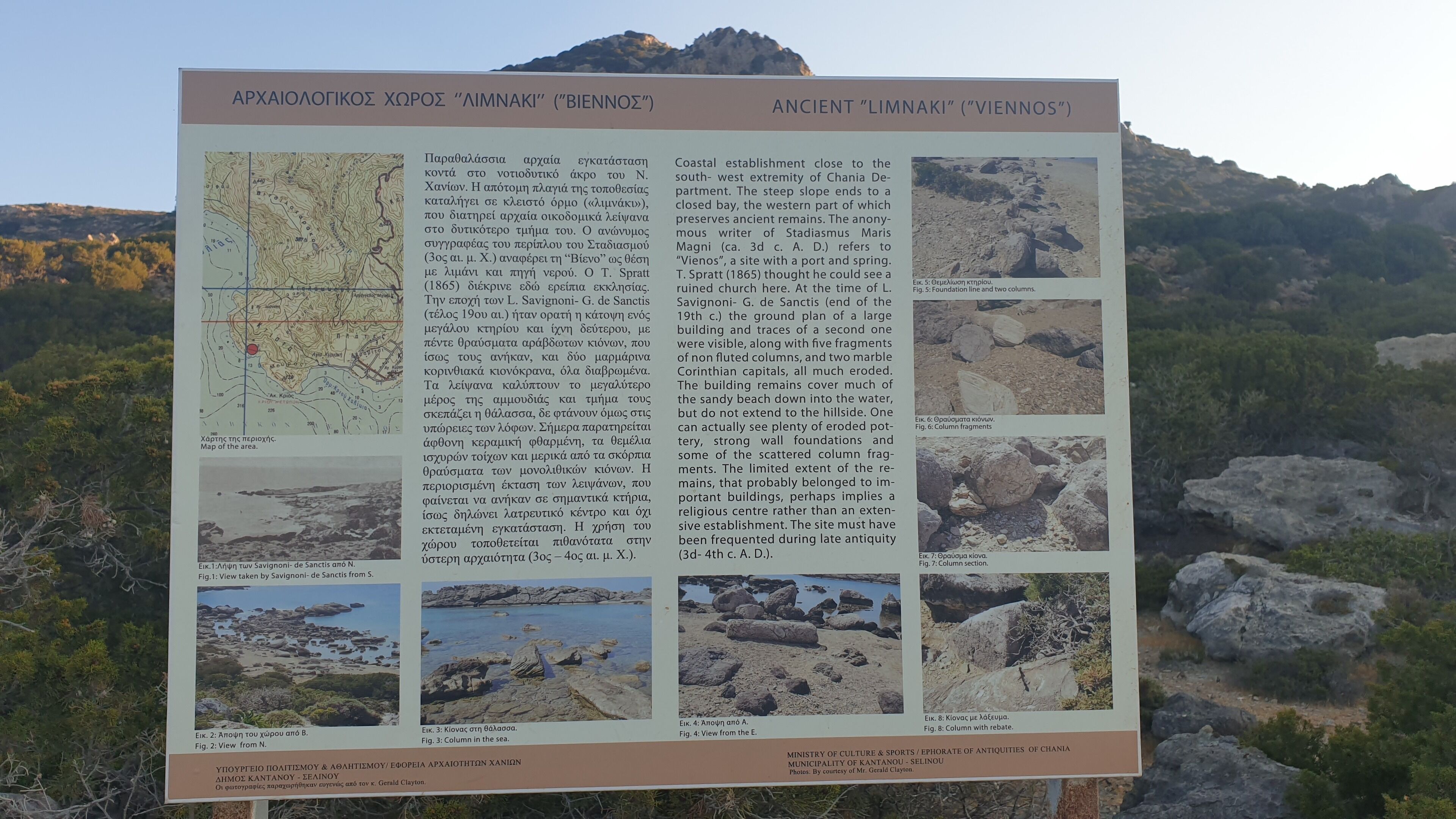 A historical site information board with a map and photos of ancient ruins.