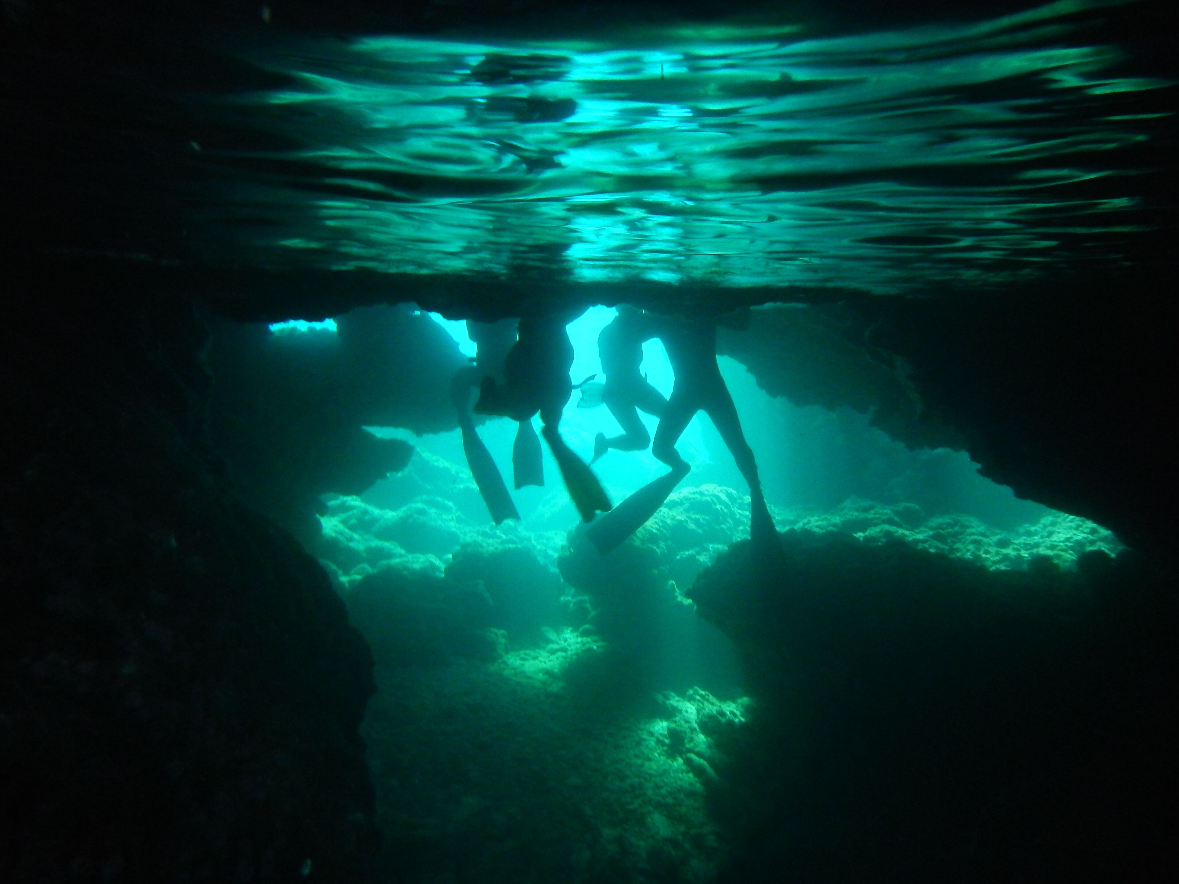 Escena submarina con buzos explorando una cueva.