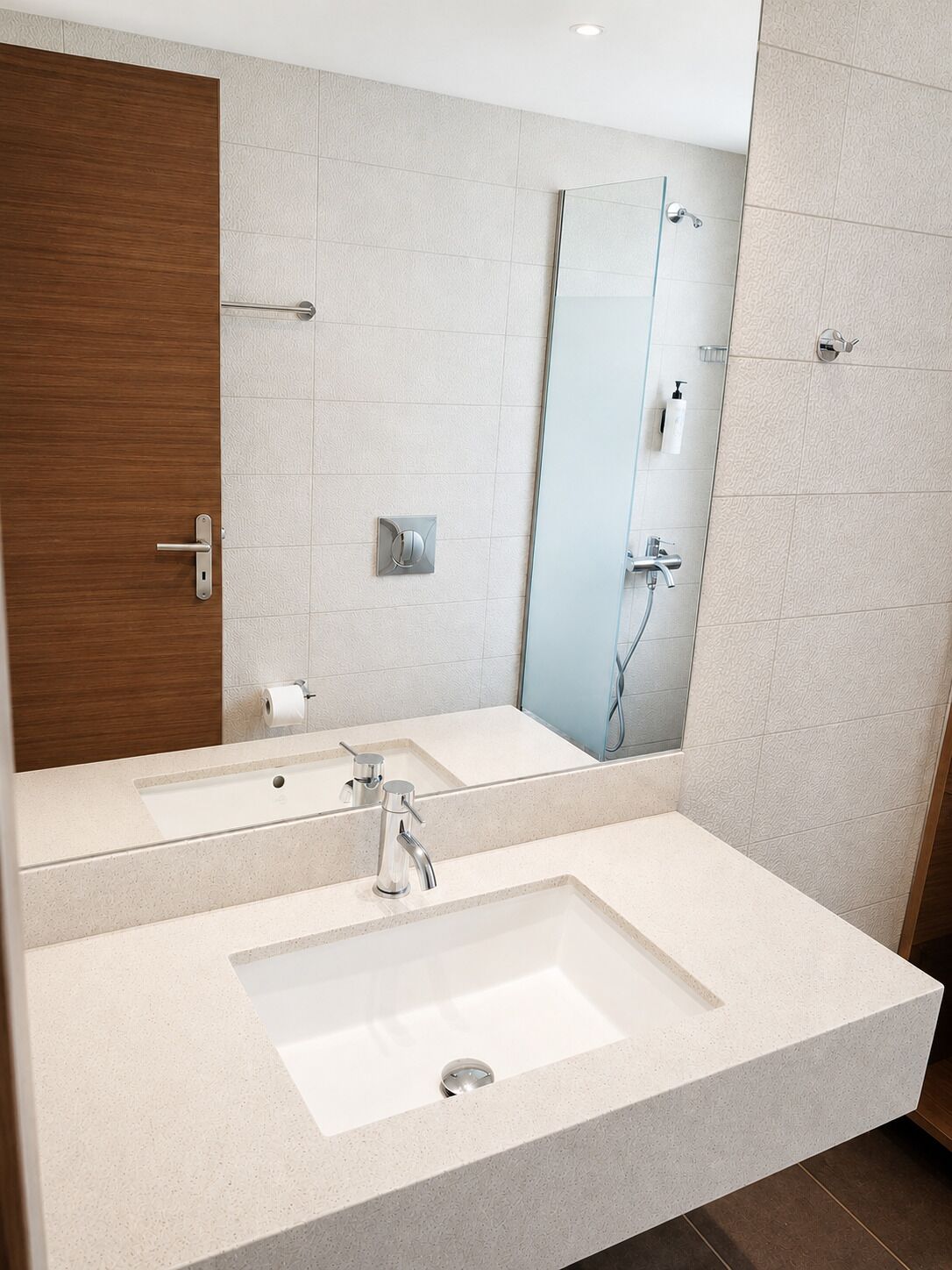 Un baño moderno con un espejo grande, dos lavamanos y una ducha.